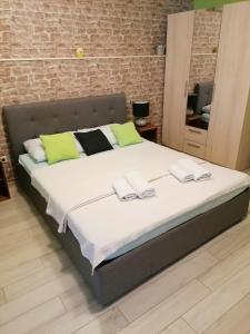 a large bed in a room with a brick wall at Bliss Apartments with free parking in Split