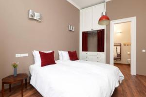een slaapkamer met een groot wit bed met rode kussens bij Venus Apartments - Italian Stylish in Boedapest