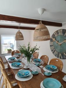 une salle à manger avec une table en bois, des chaises et une horloge dans l'établissement PATYKIEM PO WODZIE, à Jastarnia
