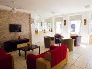 a living room with couches and chairs and a tv at Pousada do Forte Recife in Recife