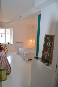 1 dormitorio con 1 cama y una pintura en la pared en Chambre privative et originale, à 20 mn de Cluny, en Trivy