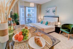 a living room with a bed and a table with food on it at Durrani Homes - Luxurious Studio near Dubai Mall with pool view in Dubai