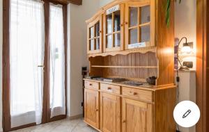 cocina con armario de madera y ventana en B&B La Terrazza, en Peschiera del Garda