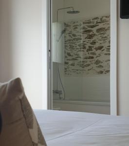 ポール・サン・ペールにあるLe Grand Jardinのベッド1台(ガラス張りのシャワー付)が備わる客室です。