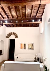 ein Wohnzimmer mit einem weißen Sofa und Holzdecken in der Unterkunft Suite Saffi 99 in Viterbo