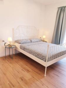 1 Schlafzimmer mit einem weißen Bett und 2 Tischen in der Unterkunft BEACH APARTMENTS MARINA DI RAGUSA in Marina di Ragusa