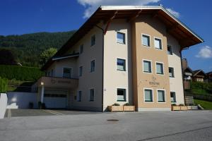 ein großes weißes Gebäude mit einem Dach in der Unterkunft Bergfink apartments in Flachau