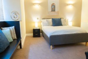 a bedroom with a large bed and a night stand at Premiere City Centre Apartment with Gated Parking and Excellent Feedback, Big Double Bedroom, Balcony, Courtyard Garden, Ideal for Long Stays, WFH, Getaways and Ongoing Contracts in Peterborough