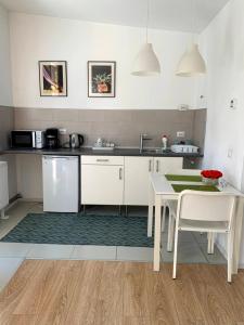 a kitchen with white cabinets and a table and a table and chairs at Casa Petri in Sînpetru