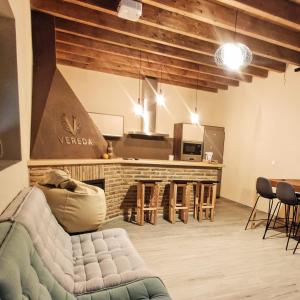 a living room with a couch and a kitchen at Casa Rural Vereda - Fábrica de Cerveza in Ledigos