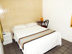 um quarto com uma cama branca e uma mesa em Pousada do Forte Recife no Recife