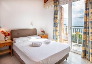 a bedroom with a large bed and a balcony at Hotel Korakakis Beach in Finikounta