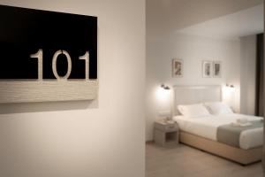 1 dormitorio con 1 cama y reloj en la pared en Roseum Boutique Hotel, en Lárnaca