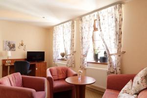 韦尼格罗德Löwenbräu am Kohlmarkt的客厅配有椅子、桌子和窗户