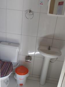 Baño blanco con aseo y lavamanos en Pousada Maria Brasil, en Paracuru