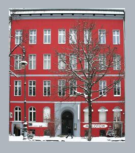 un bâtiment rouge avec un arbre devant lui dans l'établissement Ruhige Ferienwohnung in Kreuzberg, à Berlin