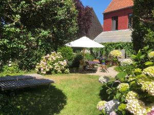 un jardín con banco y sombrilla en Beaux Temps b&b, en Aalter