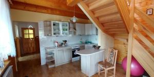 een keuken met witte kasten en een tafel op zolder bij Dom w spokojnej okolicy in Dubicze Cerkiewne