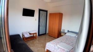 a small bedroom with a bed and a tv at House Anna Houhlia in Vourvourou