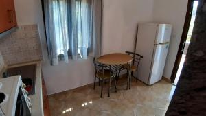 a small kitchen with a table and a refrigerator at House Anna Houhlia in Vourvourou