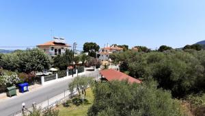 an empty street in a town with houses and trees at House Anna Houhlia in Vourvourou