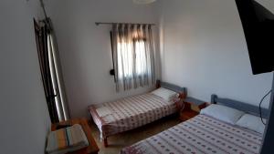 a small room with two beds and a window at House Anna Houhlia in Vourvourou
