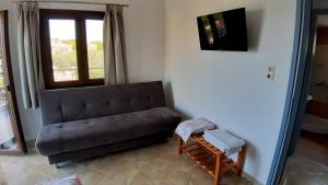 a living room with a couch and a tv at House Anna Houhlia in Vourvourou