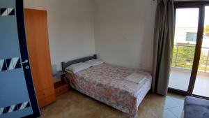 a small bedroom with a bed and a window at House Anna Houhlia in Vourvourou