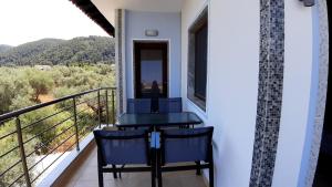 a balcony with a table and chairs and a view at House Anna Houhlia in Vourvourou