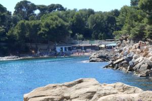 ein Wasserkörper mit Felsen im Vordergrund in der Unterkunft Particulier loue T3 en rez de jardin à 30 mètres de la plage avec un double box in La Ciotat