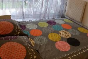 a bed with polka dot patterns on the floor at Particulier loue T3 en rez de jardin à 30 mètres de la plage avec un double box in La Ciotat