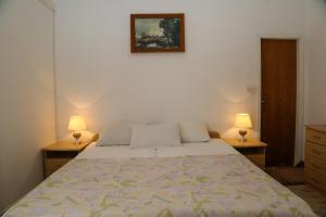 1 dormitorio con 1 cama con 2 lámparas en 2 vestidores en Apartments Butkovic, en Hvar