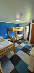 a bedroom with two bunk beds and a checkered floor at Basecamp Wales in Llanllyfni