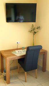 a desk with a chair and a television on a wall at Bed and Breakfast am Höhenweg in Warstein