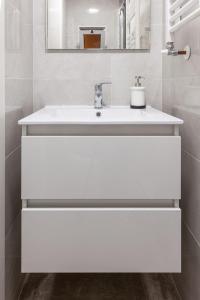 a white bathroom with a sink and a mirror at Apartamento Sambala in Ontinyent