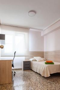 a bedroom with a bed and a desk and a window at Apartamento Sambala in Ontinyent