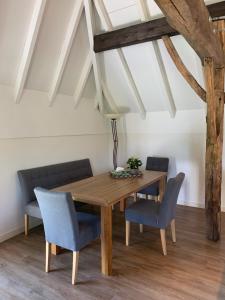 een eetkamer met een houten tafel en blauwe stoelen bij De Stal - Buitenplaats Ruitenveen, privé! in Nieuwleusen