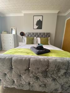 a bedroom with a large bed with a green blanket at 4 Bed - 2 Bathrooms 1 Walk in Shower - lots of Parking - Long Stays Welcome in Ipswich