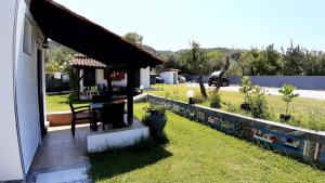 a house with a patio with a table in a yard at House Anna Houhlia in Vourvourou