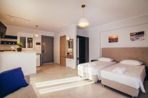 a living room with two beds and a kitchen at Zen Apartments in Laganas