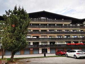 ein Gebäude mit zwei davor geparkt in der Unterkunft Apartment Vera in Saalfelden am Steinernen Meer