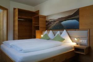 ein Schlafzimmer mit einem großen Bett mit einem Gemälde an der Wand in der Unterkunft Bergfink apartments in Flachau