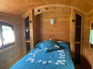 1 cama en la esquina de una cabaña de madera en La Roulotte du Randonneur, en Rimbach-près-Masevaux