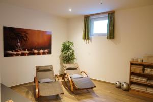 ein Wohnzimmer mit zwei Stühlen und einem Fenster in der Unterkunft Bergfink apartments in Flachau
