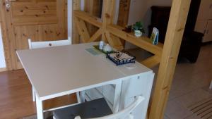 a white table and chair in a room with a shelf at Appartement Schönberger in Rodder