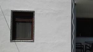 a mirror on the side of a white wall at House Anna Houhlia in Vourvourou