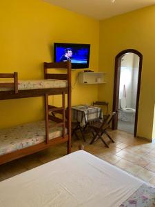 a room with a tv and a bunk bed at Pousada Bertimar in Bertioga +20 photos