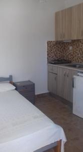 a kitchen with a white bed in a room at House Anna Houhlia in Vourvourou