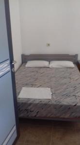 a bed with two pillows on it in a room at House Anna Houhlia in Vourvourou