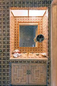 
a bathroom with a large mirror and a bed at La Puertecita Boutique Hotel in San Miguel de Allende
